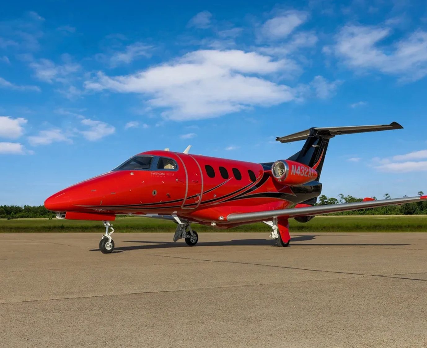 Red private jet on airport runway.