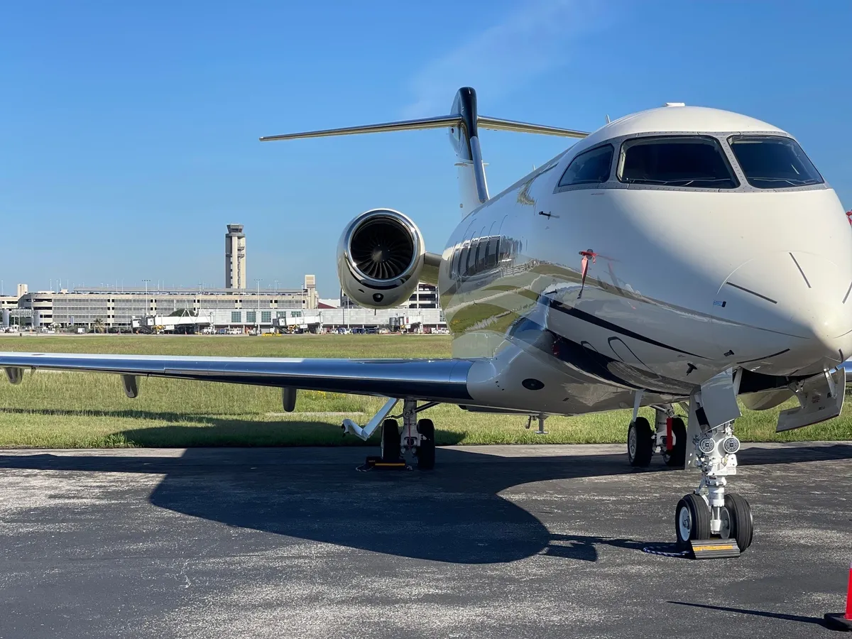 Private jet parked on airport tarmac.