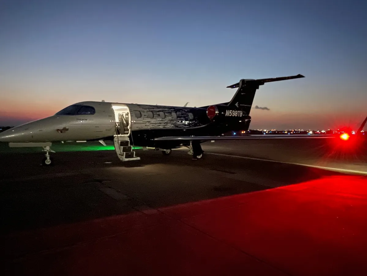 Private jet on runway at dusk.